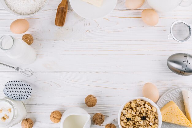 Una vista aérea de ingredientes alimentarios saludables y herramientas en mesa de madera blanca