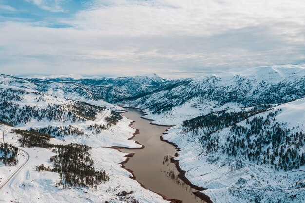 Vista aérea del lago de invierno en montañas nevadas