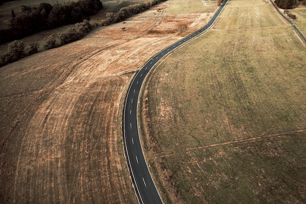 Vista aérea de una larga carretera asfaltada rodeada de campos