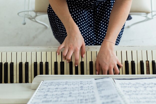 Vista aérea de la mano de una mujer tocando el piano.