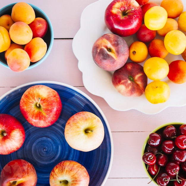 Vista aérea de las manzanas; ciruela; melocotón y cerezas en el escritorio de madera