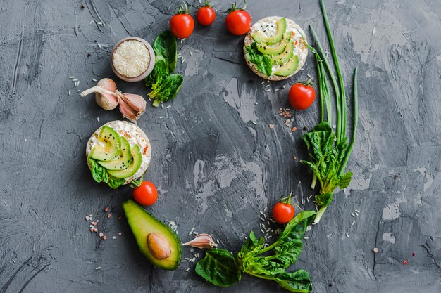 Vista aérea de un marco circular hecho con vegetales frescos sobre una superficie texturizada