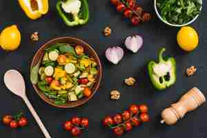 Foto gratuita vista aérea de una mezcla de vegetales hechos en casa con ingredientes en la encimera de la cocina negra