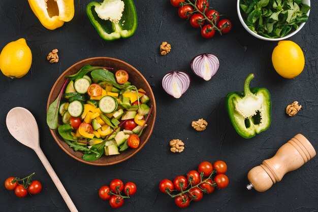 Vista aérea de una mezcla de vegetales hechos en casa con ingredientes en la encimera de la cocina negra