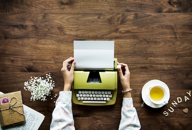 Foto gratuita vista aérea de una mujer usando una máquina de escribir retro ocio y concepto de ocio de domingo