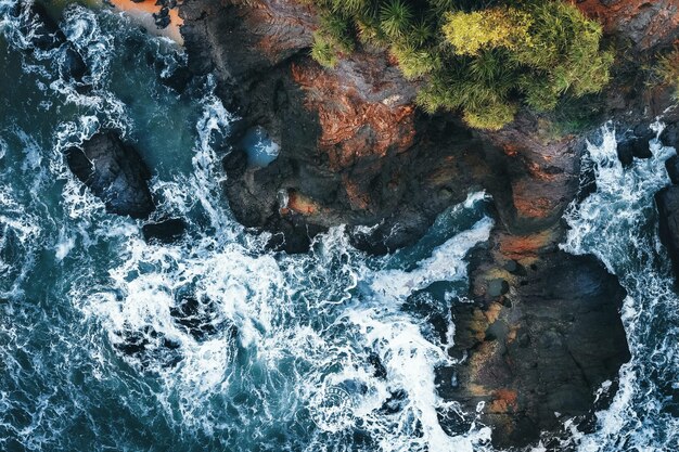 Vista aérea de las olas del mar chocando en los acantilados