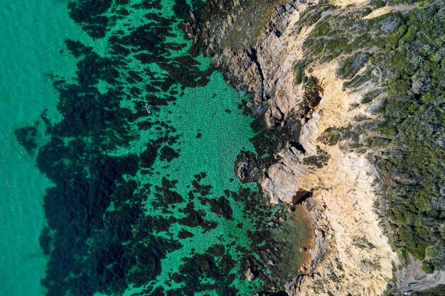 Vista aérea de las olas rompiendo en las rocas