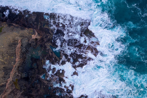 Vista aérea de las olas rompiendo en las rocas