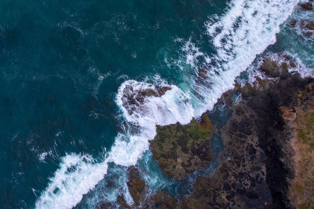 Vista aérea de las olas rompiendo en las rocas