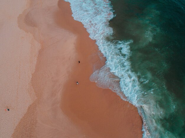 Vista aérea de la orilla del mar con varias personas en ella