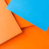 Foto gratuita una vista aérea de papel artesanal azul sobre el fondo liso de color naranja