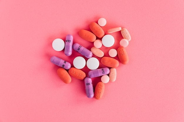 Una vista aérea de pastillas de colores sobre fondo rosa
