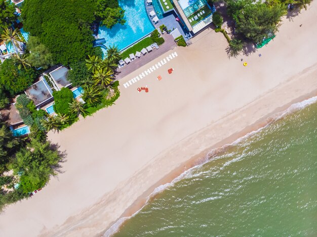 Vista aérea de piscina con mar y playa.