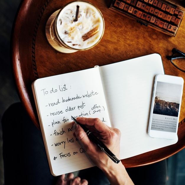 Vista aérea del primer de la escritura de la mano para hacer la lista en el café