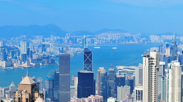 Vista aérea del puerto de Victoria con el horizonte de Hong Kong y rascacielos urbanos en el día.