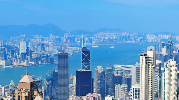 Vista aérea del puerto de Victoria con el horizonte de Hong Kong y rascacielos urbanos en el día.