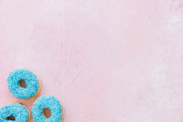 Foto gratuita vista aérea de rosquillas azules sobre fondo rosa