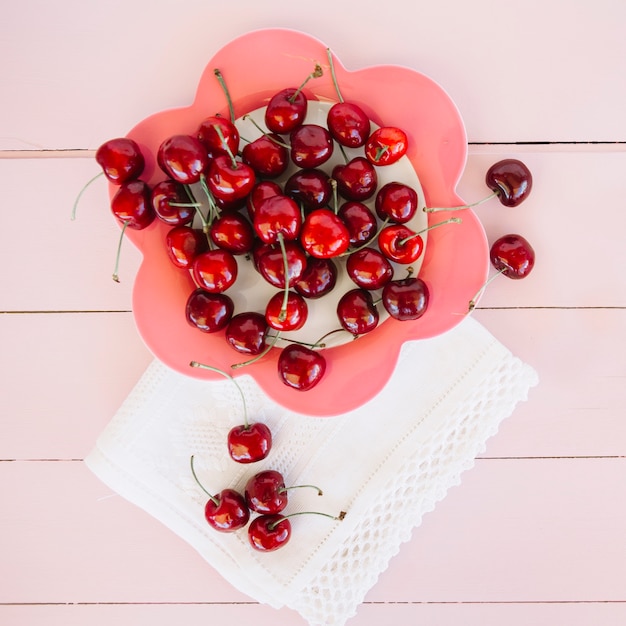 Foto gratuita vista aérea de la servilleta cerca de cerezas en plato con forma de flor