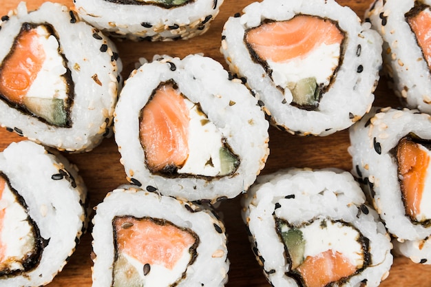 Una vista aérea de sushi con queso; sésamo; salmón y aguacate