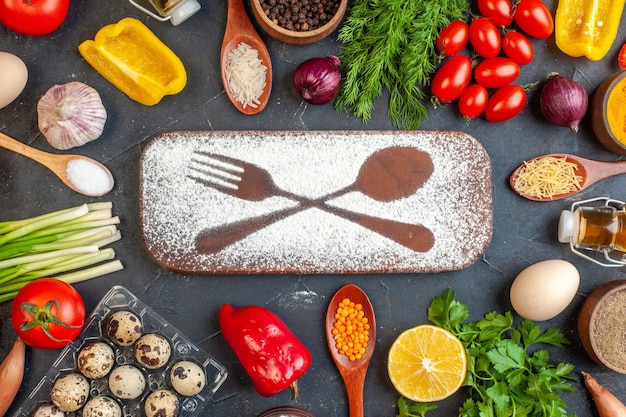 Vista aérea de la tabla de cortar con un cuchillo tenedor de harina dibujado entre verduras frescas diferentes especias