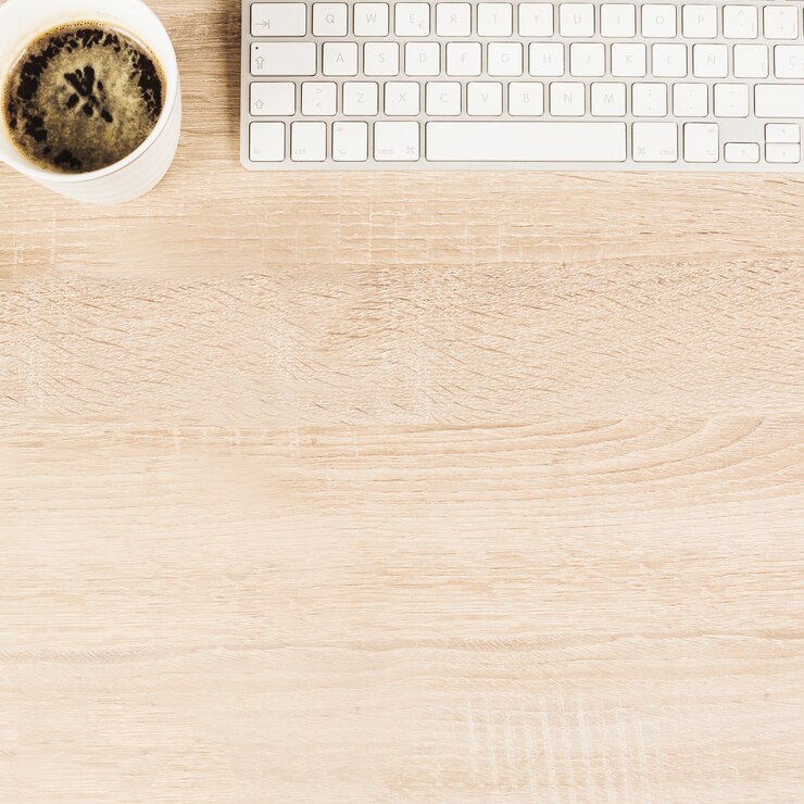 Foto gratuito una vista aérea de la taza de café y el teclado en la mesa de madera