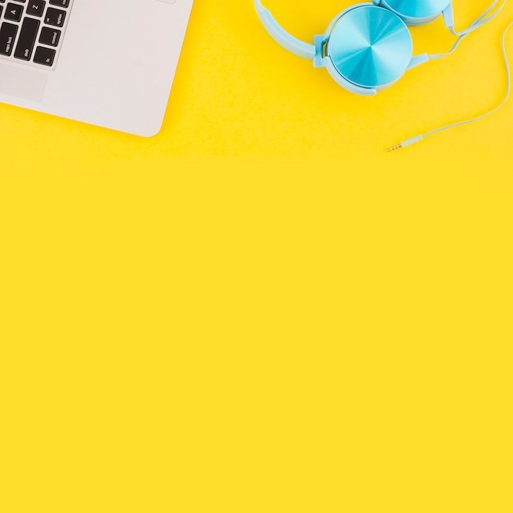 Foto gratuito vista aérea del teclado de la computadora portátil y auriculares sobre fondo amarillo
