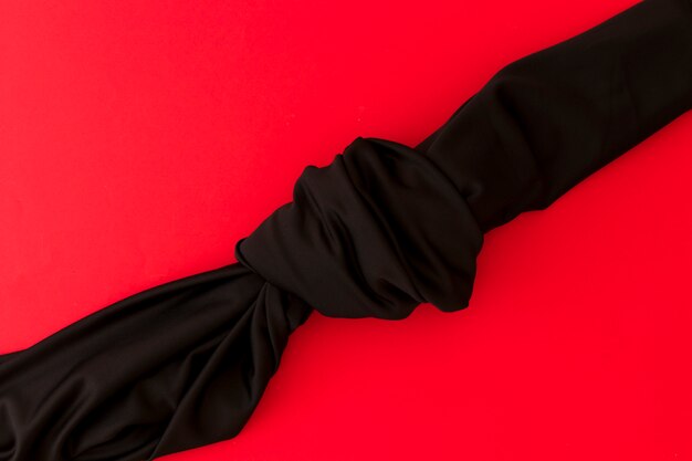 Vista aérea de tela nudo negro sobre fondo rojo