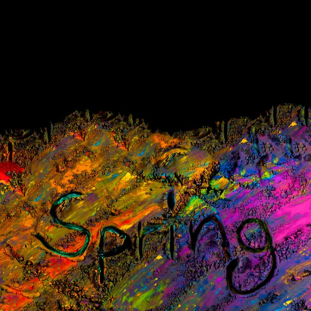 Vista aérea del texto de primavera escrito a mano en polvo holi colorido
