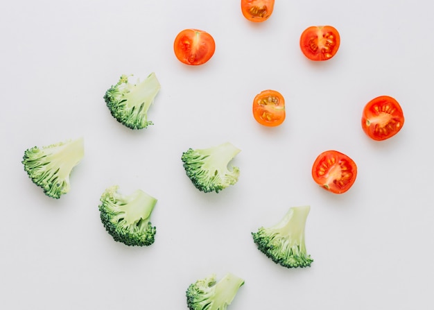 Una vista aérea de tomates cherry y brócoli sobre fondo blanco