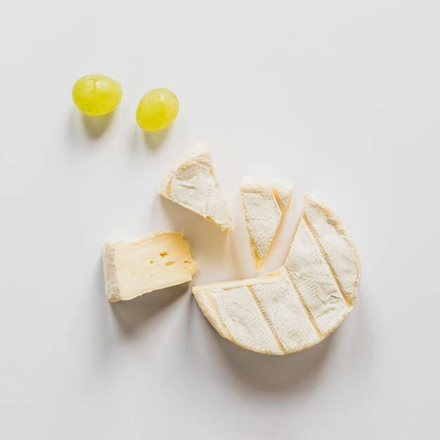 Una vista aérea de las uvas y los bloques de queso aislados sobre fondo blanco