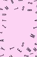 Foto gratuita vista aérea de varios alfabetos negros sobre fondo rosa