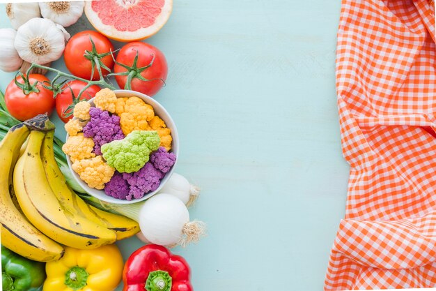 Una vista aérea de verduras sanas y servilleta sobre el fondo de color