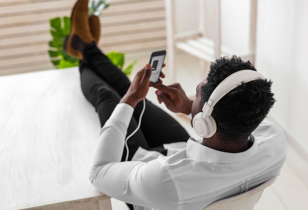 Foto gratuita vista alta desde detrás del hombre de tiro escuchando música