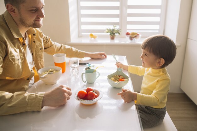 Vista alta familia tomando el desayuno en la cocina