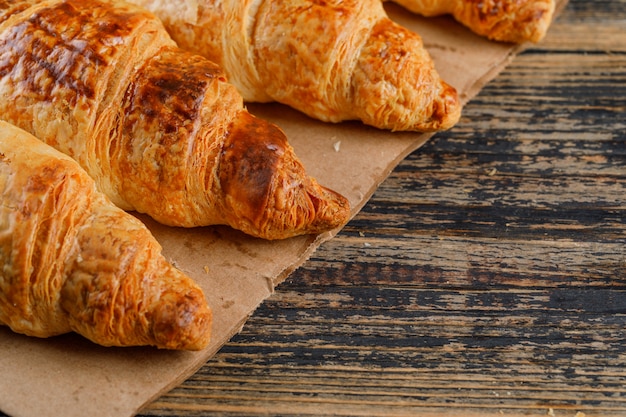 Vista de alto ángulo de croissants en bolsa de madera y papel