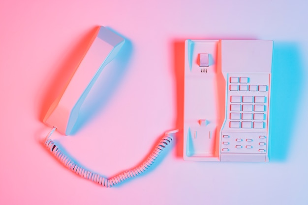 Vista de alto ángulo de teléfono fijo retro rosa con receptor