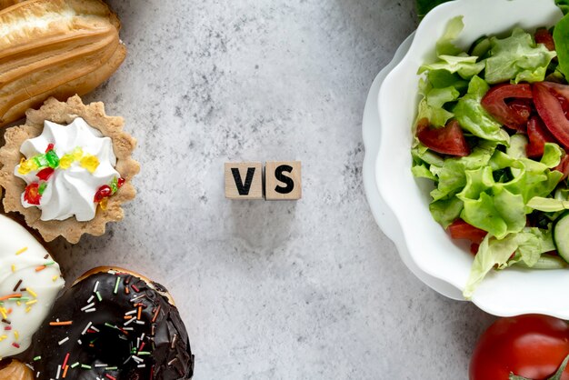 Vista de ángulo alto de alimentos saludables y no saludables sobre fondo concreto