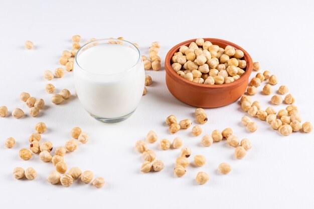 Vista de ángulo alto avellanas limpias con vaso de leche