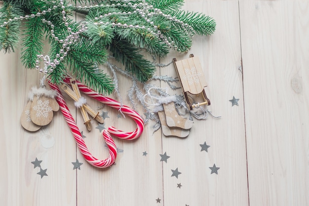 Vista de ángulo alto de bastones de caramelo rodeados de adornos navideños en una mesa de madera