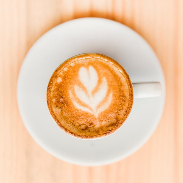 Vista de ángulo alto de café con leche en mesa de madera