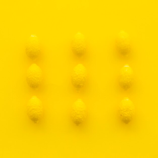 Vista de ángulo alto de caramelos de limón sobre superficie amarilla
