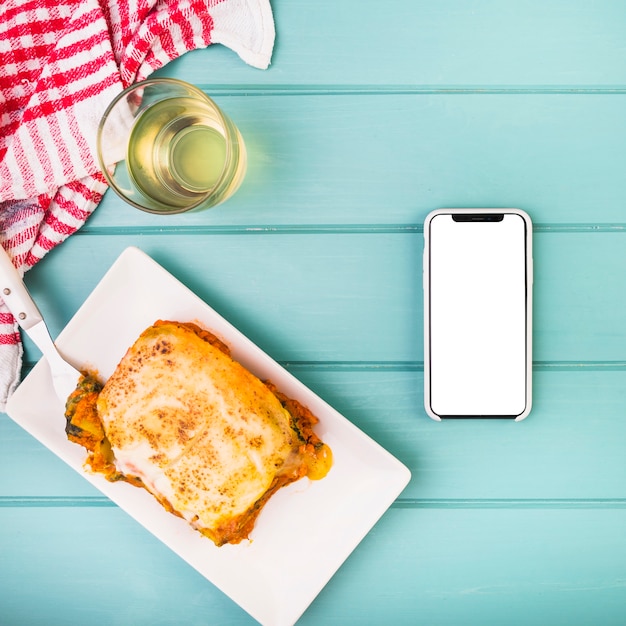 Foto gratuita vista de ángulo alto de comida deliciosa y teléfono inteligente en la mesa