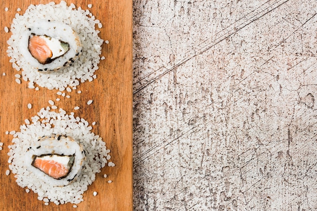 Vista de ángulo alto de delicioso sushi en bandeja de madera