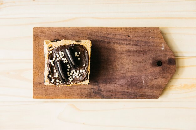 Foto gratuita vista de ángulo alto de deliciosos pasteles en tabla de cortar de madera