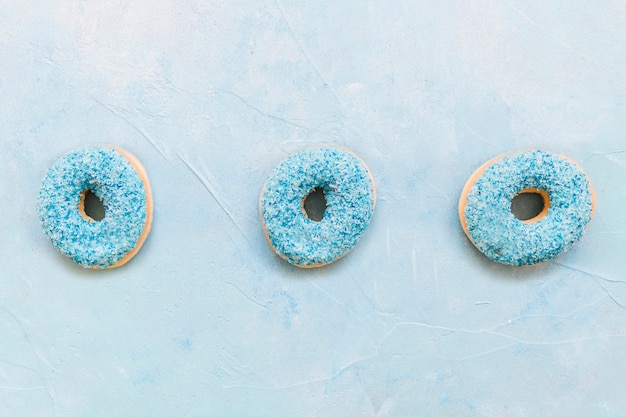 Foto gratuita vista de ángulo alto de donuts sobre fondo azul