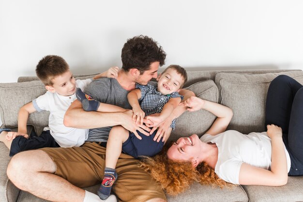 Vista de ángulo alto de familia feliz divirtiéndose en el sofá