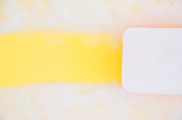 Vista de ángulo alto del jabón de limpieza de esponja sud sobre fondo amarillo