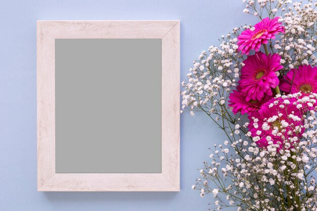 Vista de ángulo alto del marco vacío con flores rosadas y aliento del bebé