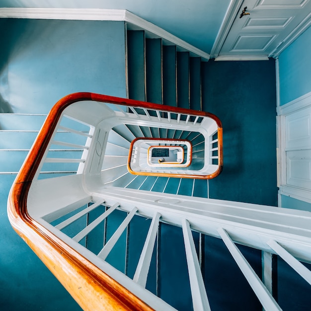 Vista de ángulo alto de una moderna escalera de caracol en una exposición bajo las luces