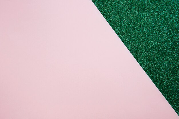 Vista de ángulo alto de papel de cartón rosa en alfombra verde